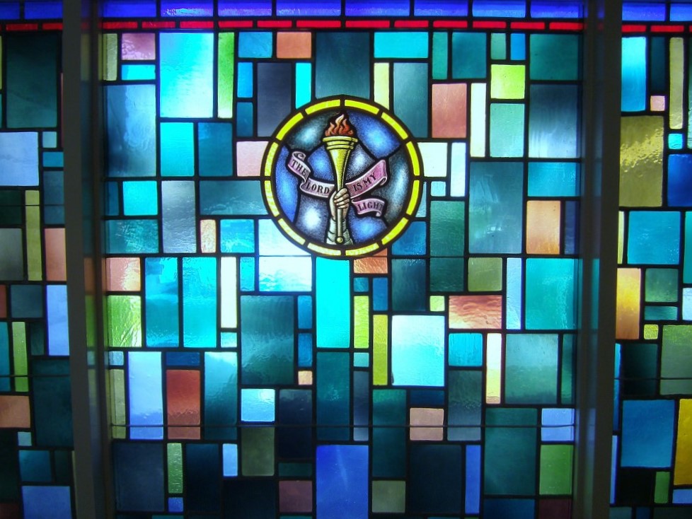 Stained-glass window from Boerne United Methodist Church showing hand with torch and legend "The Lord is my light"