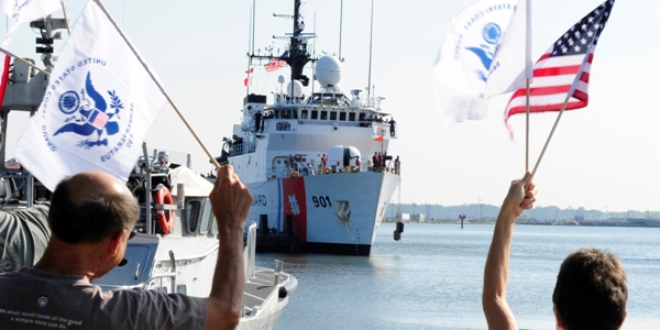 Flag-waving family members welcome home the crew of the Coast Guard Cutter Bear