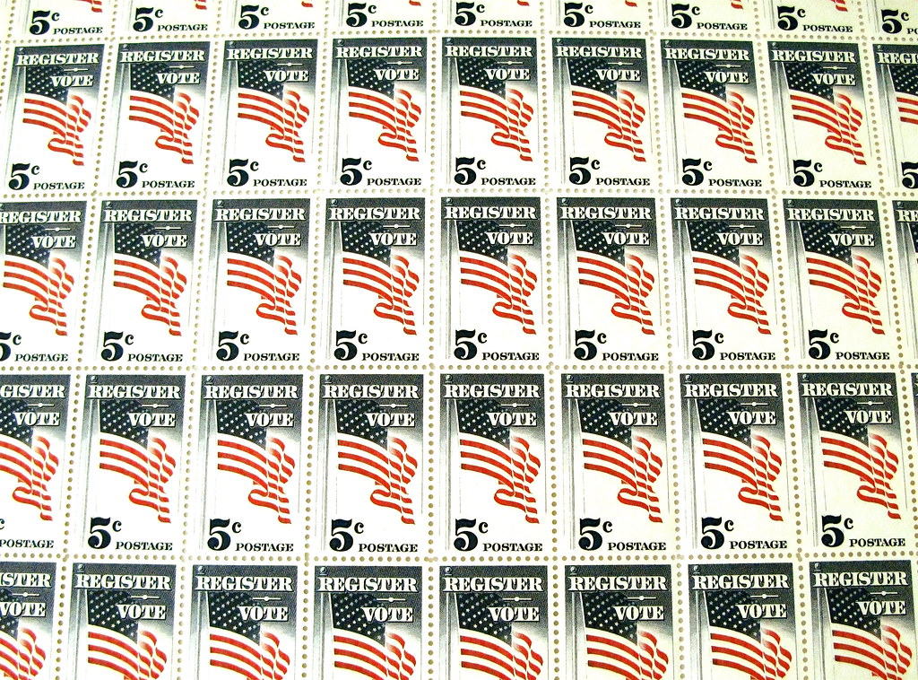 Sheet of US 5c stamps reading "Register/Vote"