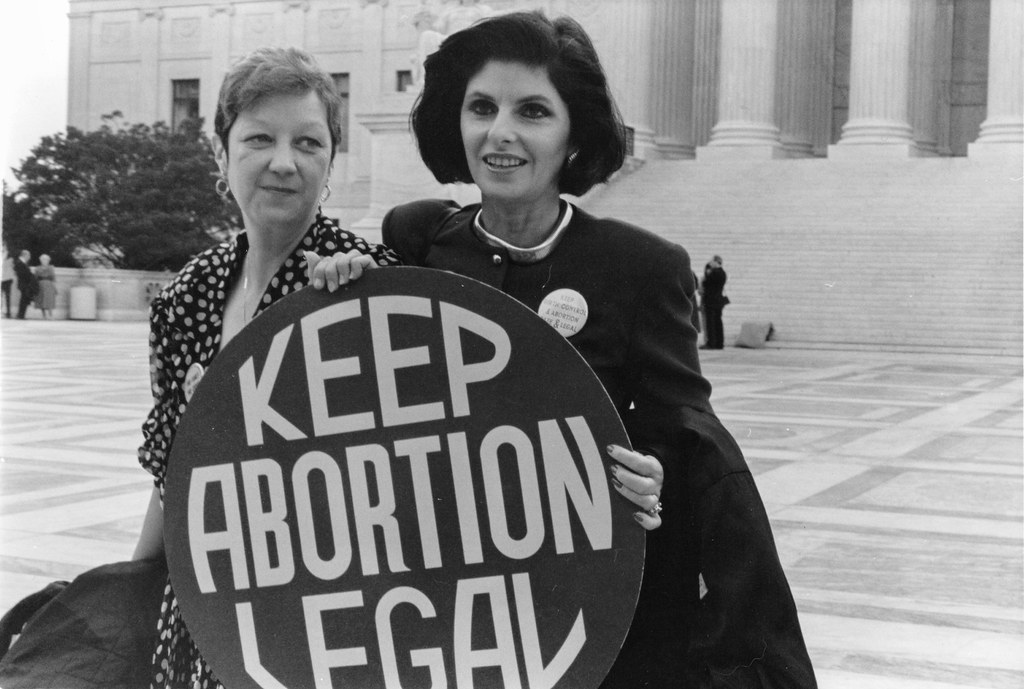 Norma McCorvey and Gloria Allred hold a "Keep Abortion Legal" sign on the steps of the US Supreme Court