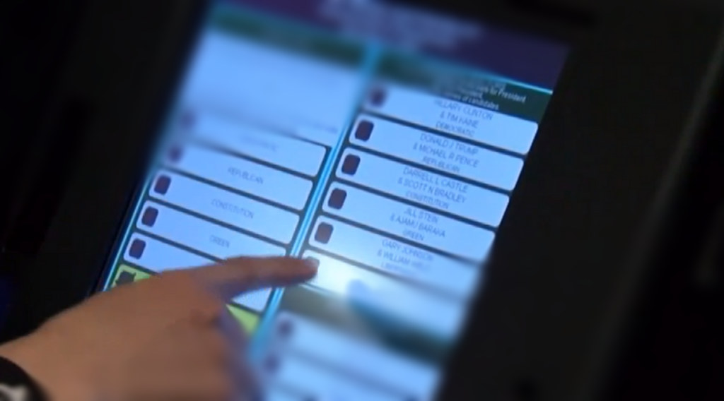 Hand selecting choices at the screen of an electronic voting machine