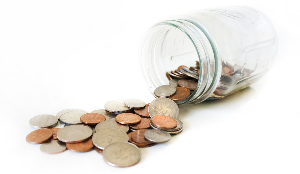 Jar of collected coins spills out onto a surface.