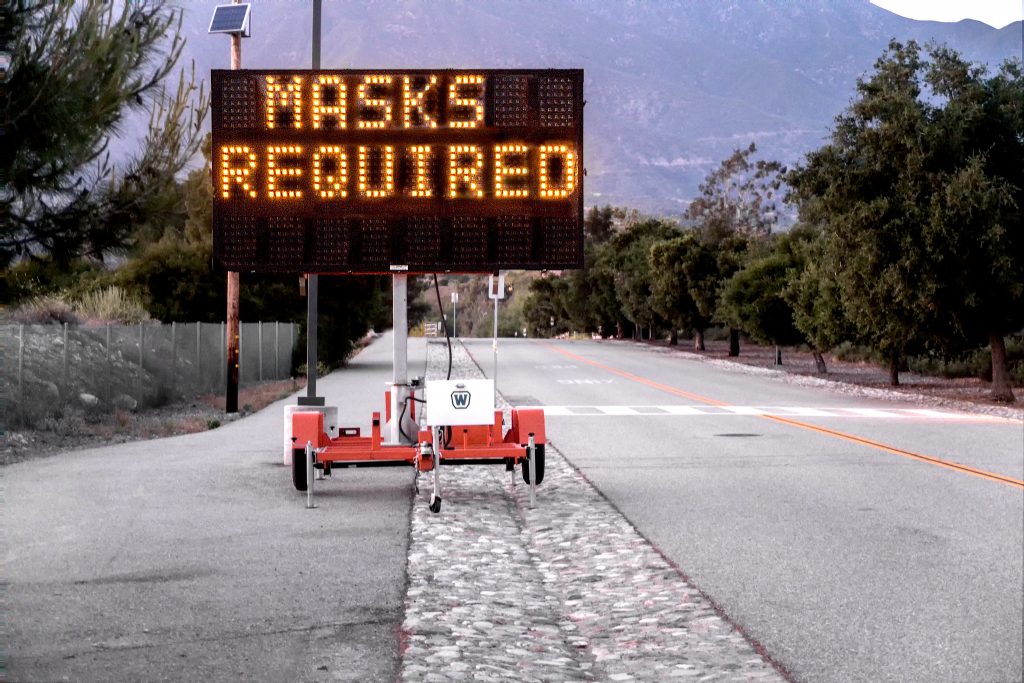 The message "Masks Required" on a digital roadway sign.