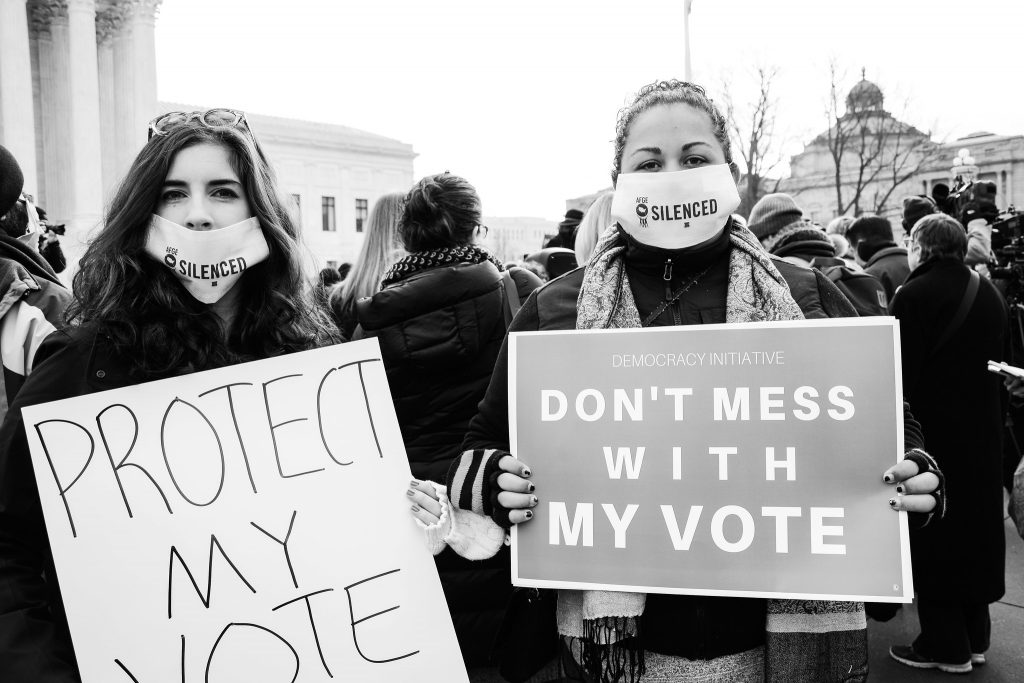 Two protester with signs advocating for the protection of their voter rights