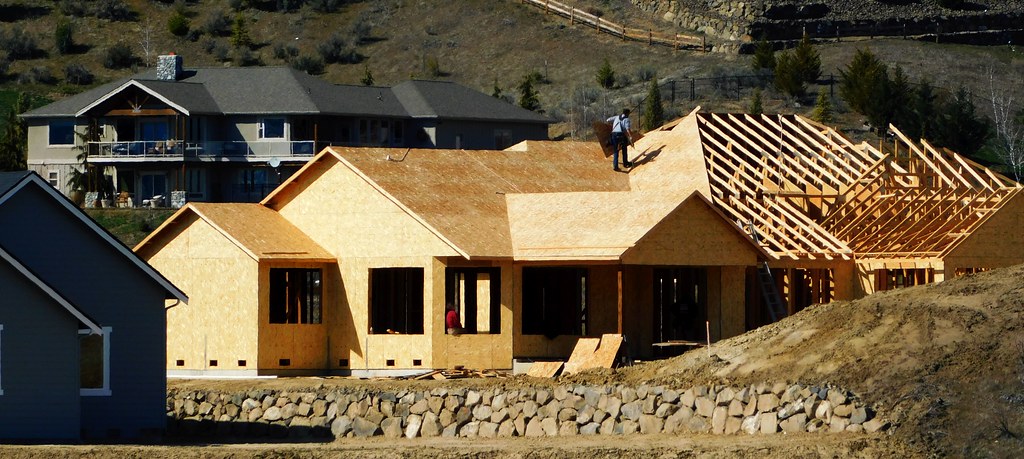 A cluster of houses being built in the foreground obscuring beautiful scenery in the background