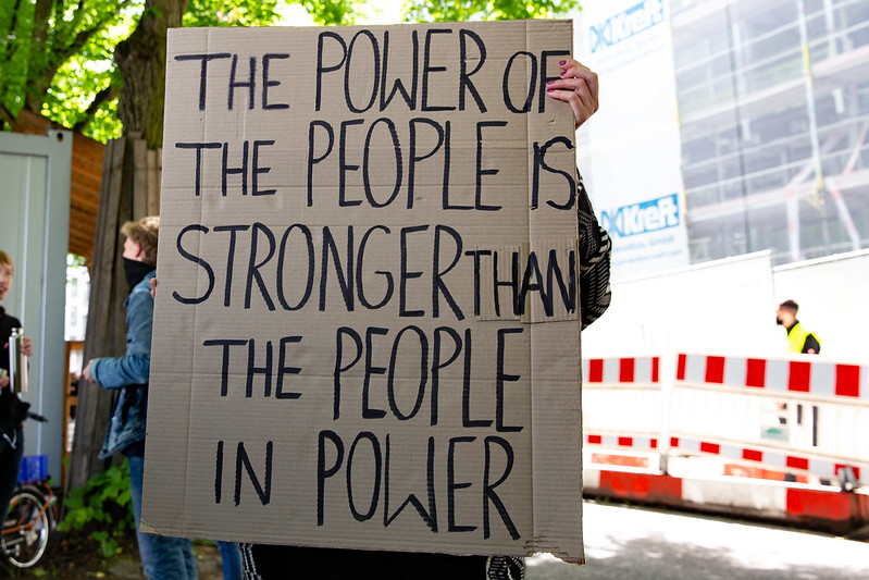 Sign which reads "The power of the people is stronger than the people in power"