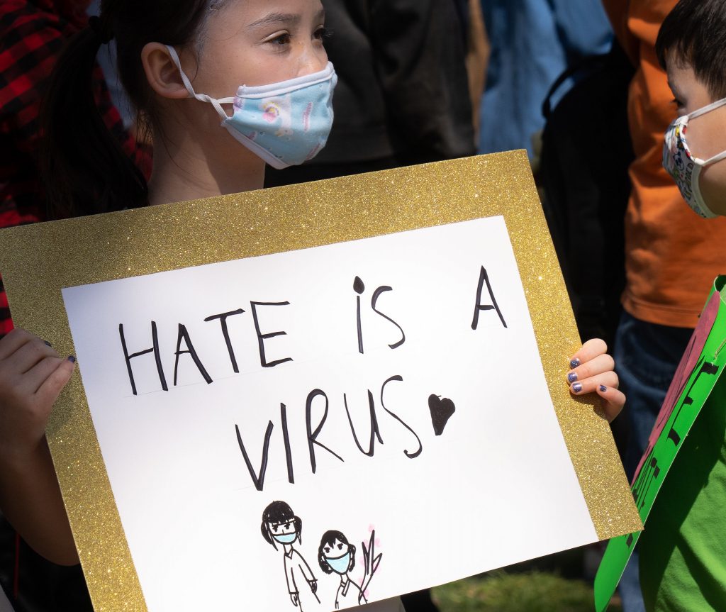 Handmade sign which reads "Hate is a virus"