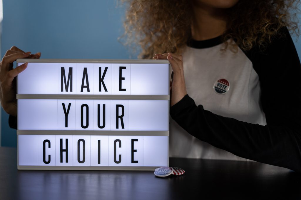Woman holding a sign which reads "Make Your Choice"