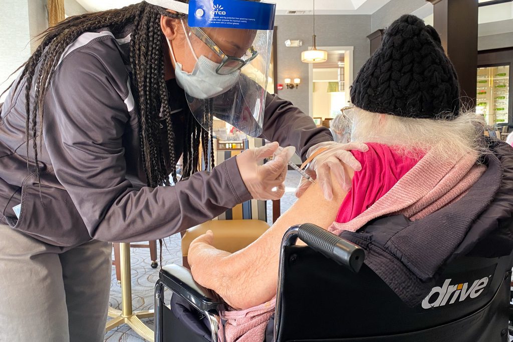 Nurse administering a vaccine shot to a patient