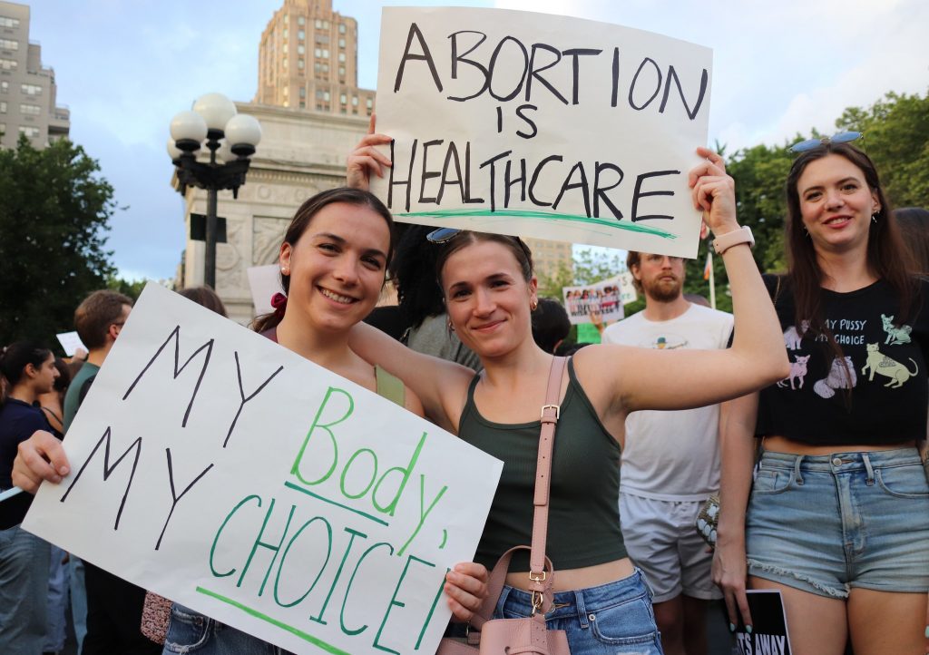 Two protesters holding up pro-abortion signs at a rally.
