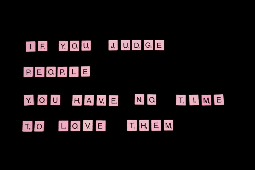 "If  you judge people, you have no time to love them" written with Scrabble pieces