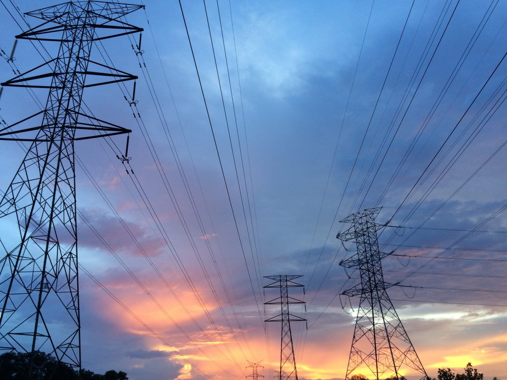 Electricity lines and towers under a sky at sunset.