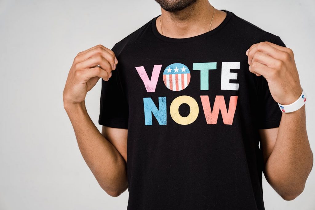 Man in black shirt with VOTE NOW on the front