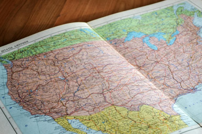 map of the united States book laid open on brown wooden surface