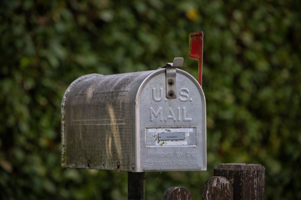 Classic US mailbox with a green natural setting in background.