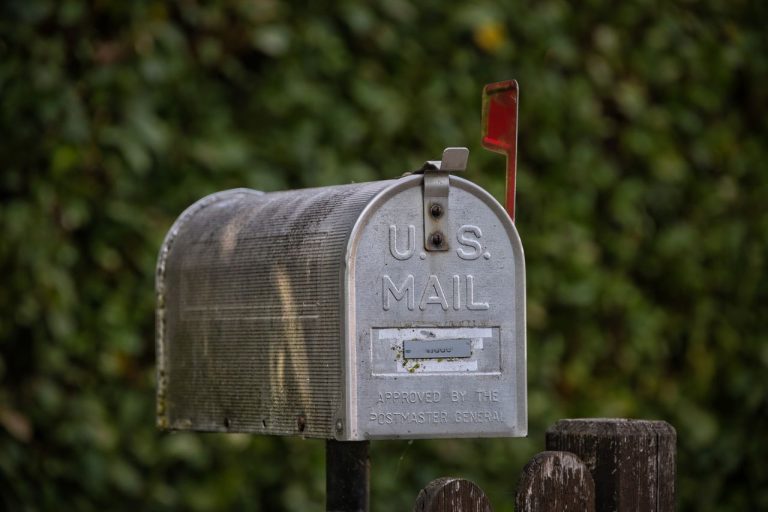 Classic US mailbox with a green natural setting in background.